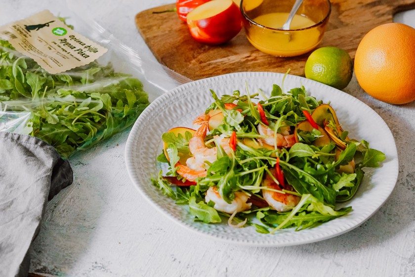 Salad with wild rocket leaves, grilled shrimps, peaches and chili