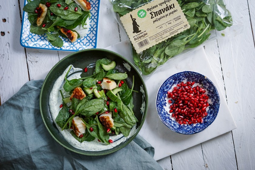 Salad with baby spinach leaves, halloumi cheese and pomegranate seeds