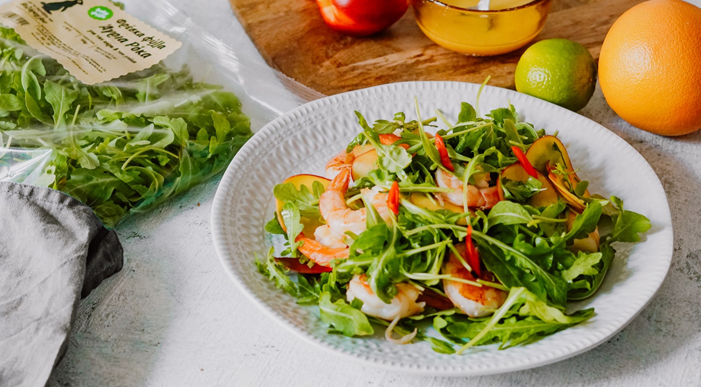Salad with wild rocket leaves, grilled shrimps, peaches and chili