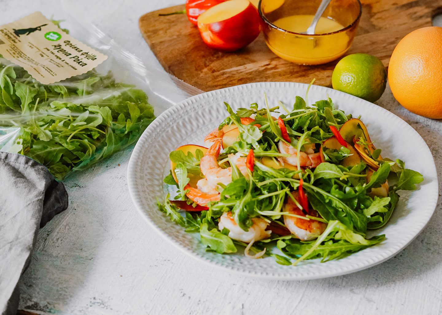 Salad with wild rocket leaves, grilled shrimps, peaches and chili