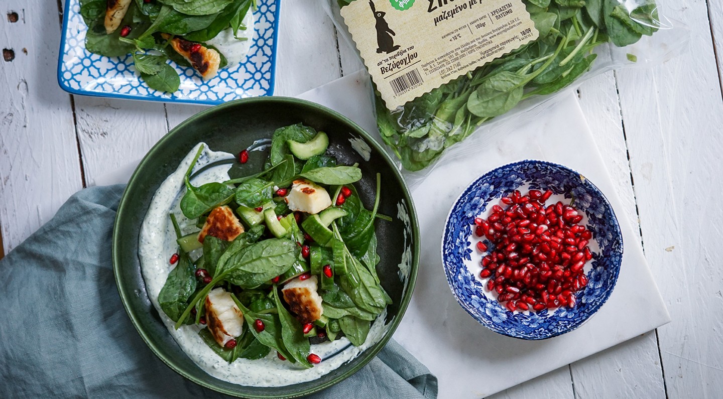 Salad with baby spinach leaves, halloumi cheese and pomegranate seeds